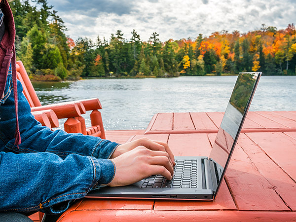 Laptop Connected to WiFi near a Lake with Fall Foliage visible